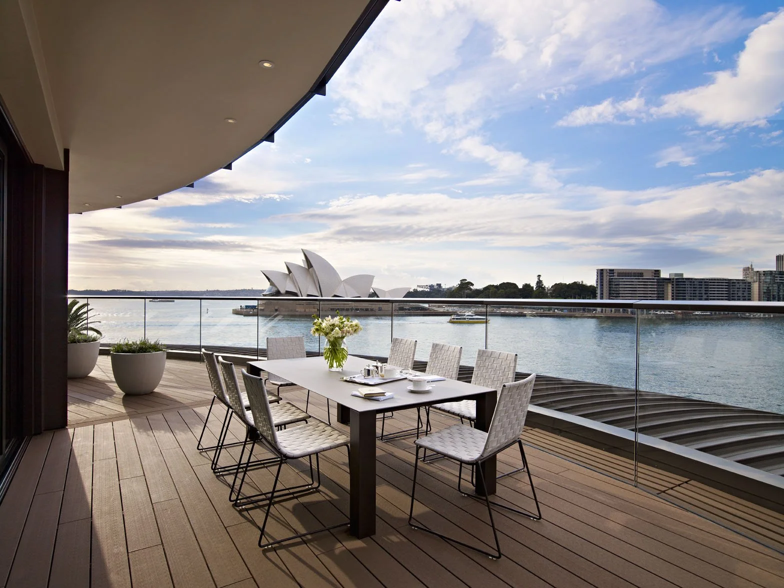The private outdoor terrace of the Sydney Suite with dining table facing the harbour and Opera House.
