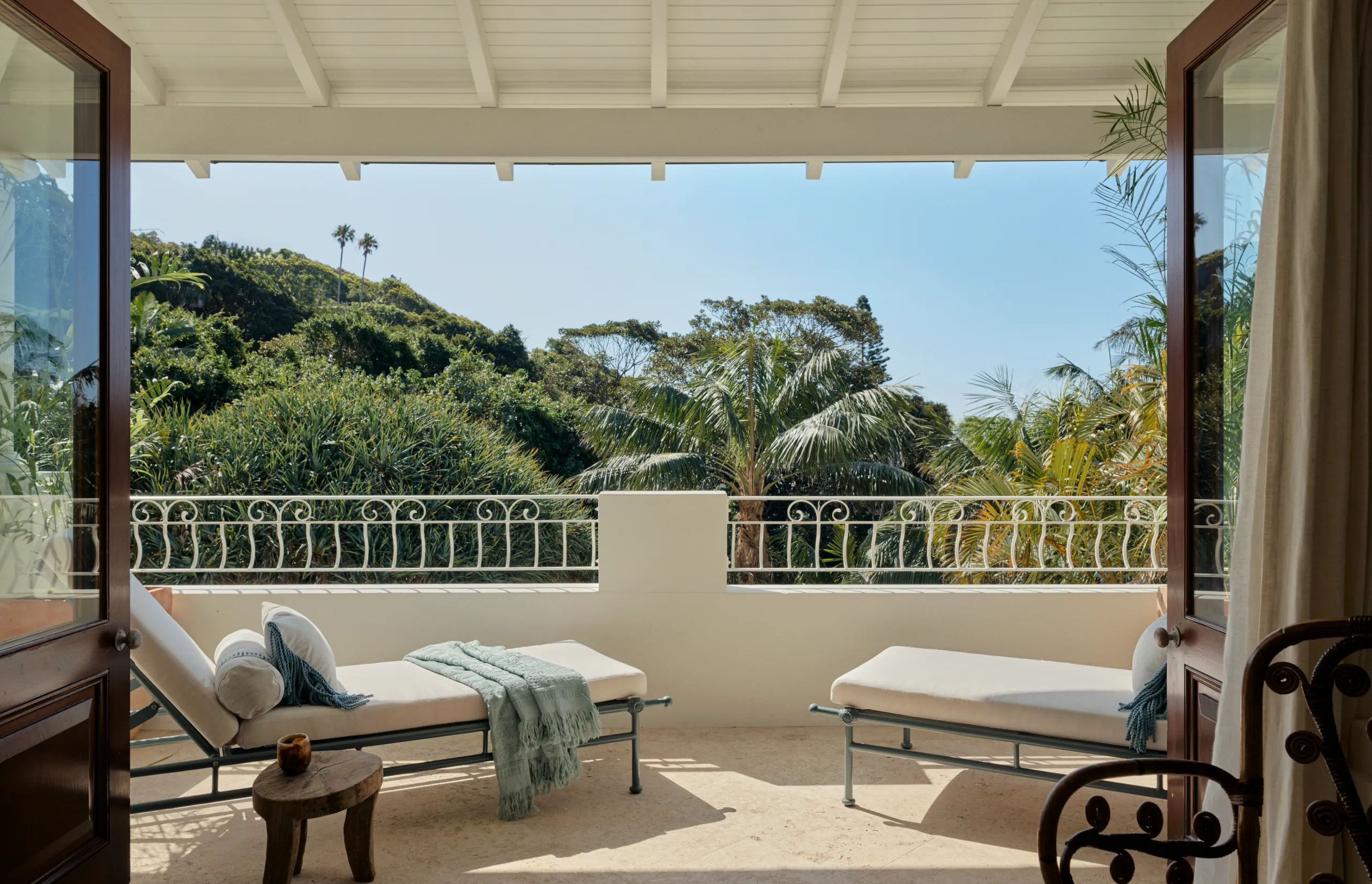 A private balcony with two chaise longues looking out over the headland.